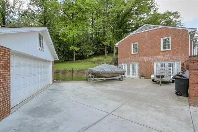 a view of house with backyard and trees in the background