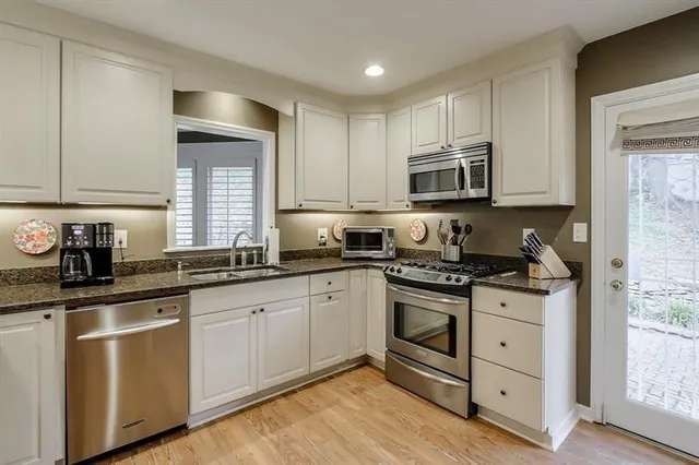 a kitchen with granite countertop white cabinets and appliances