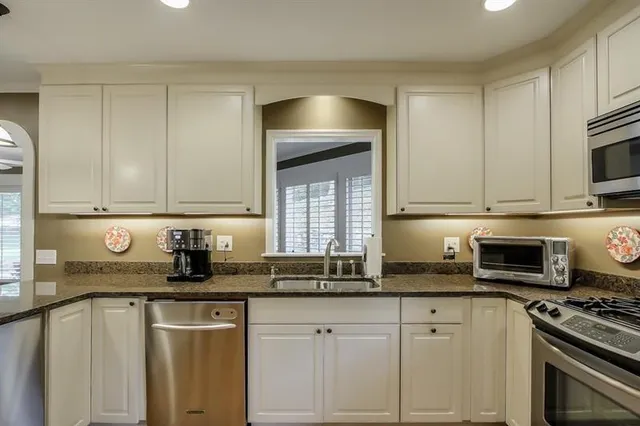 a kitchen with sink a microwave and cabinets