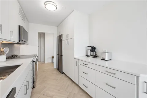 a kitchen with a sink cabinets and window