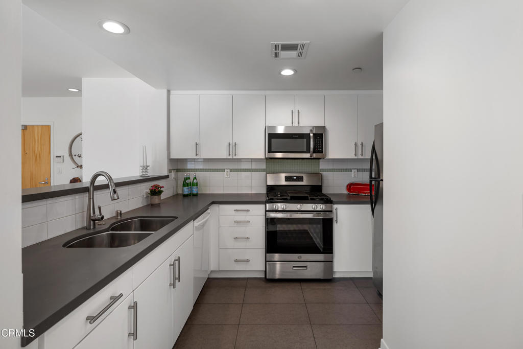 159 West Green Street, Unit 502A Pasadena, CA 91105 - Photo 14 of 40 a kitchen with stainless steel appliances a sink stove and cabinets