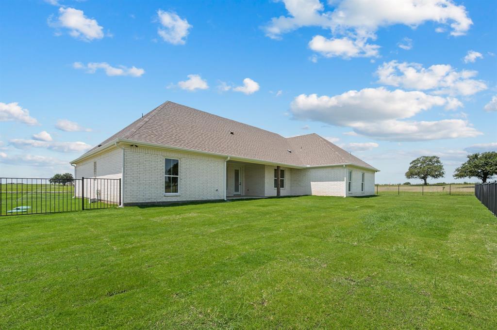 2705 Gospel Road Tolar, TX 76476 - Photo 29 of 36 Expansive green lawn bordering a white brick residence with a grey shingle roof
