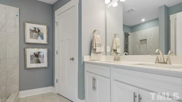 a bathroom with double vanity sinks and a mirror