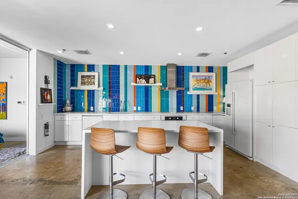 a kitchen with stainless steel appliances granite countertop a table and chairs in it