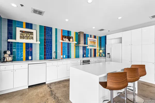 a kitchen with stainless steel appliances granite countertop a couch and cabinets