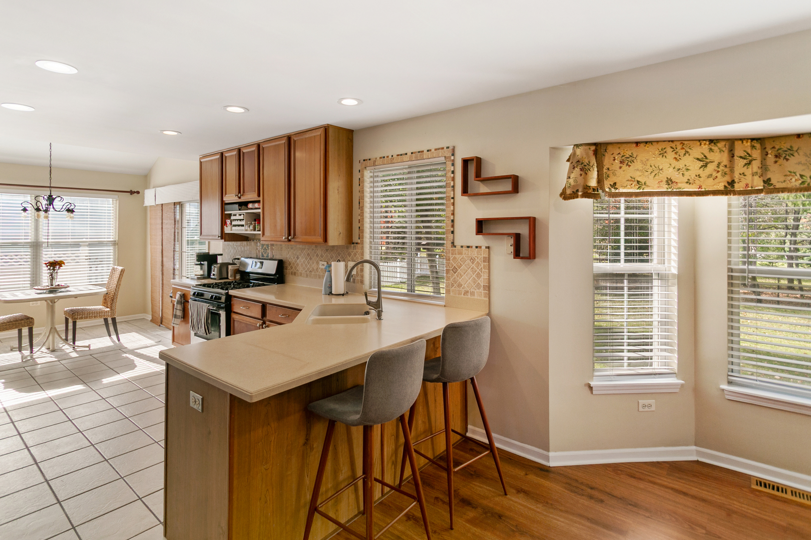 67 Raven Drive Aurora, IL 60506 - Photo 7 of 30 a kitchen with stainless steel appliances a dining table chairs and a wooden floor