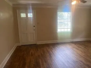 an empty room with wooden floor and windows