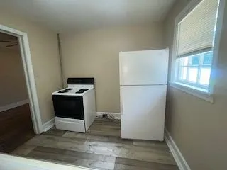 a view of kitchen with wooden floor and electronic appliances