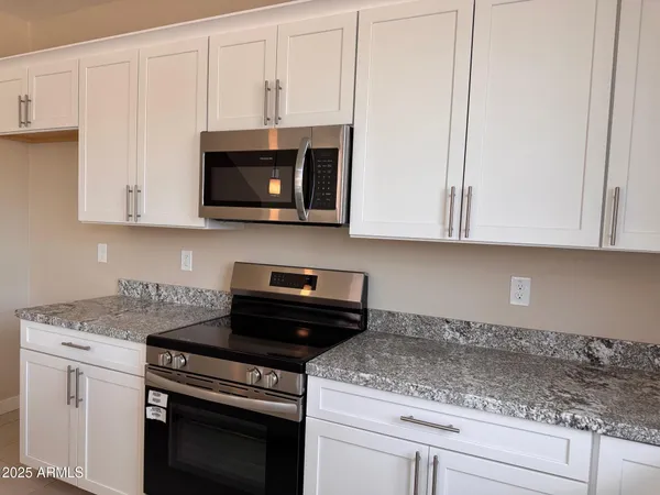 a kitchen with granite countertop a sink stove and cabinets