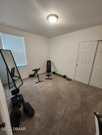 a room with gym equipment and a view of living room