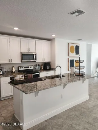 a kitchen with stainless steel appliances granite countertop a sink and a stove top oven