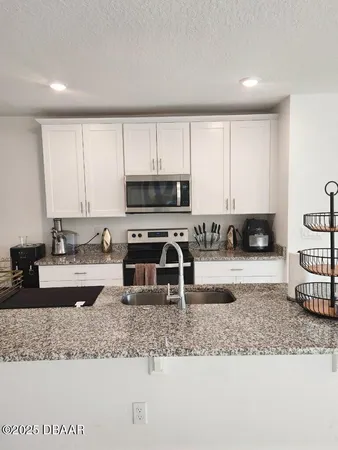 a kitchen with granite countertop a stove a sink and a granite counter tops