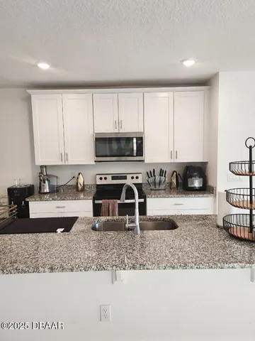 a kitchen with granite countertop a stove a sink and a granite counter tops