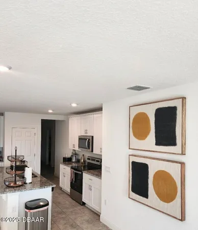 a kitchen with stainless steel appliances a stove top oven a sink a chimney and wooden floor