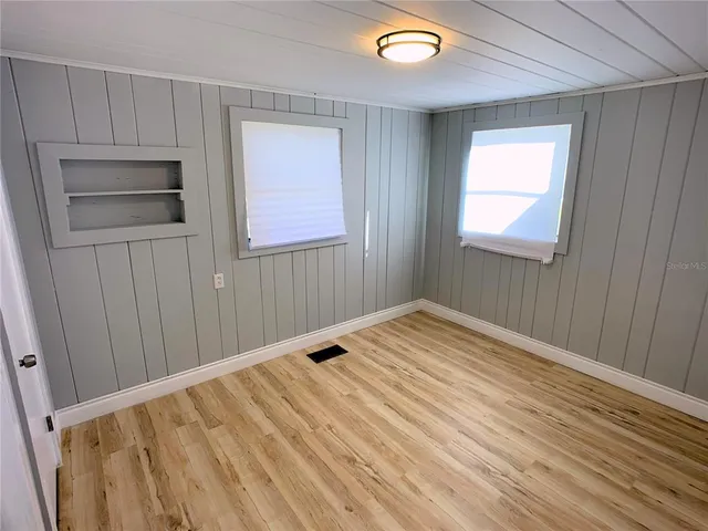 a view of empty room with wooden floor