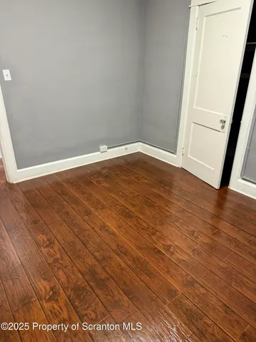 a view of a room with wooden floor