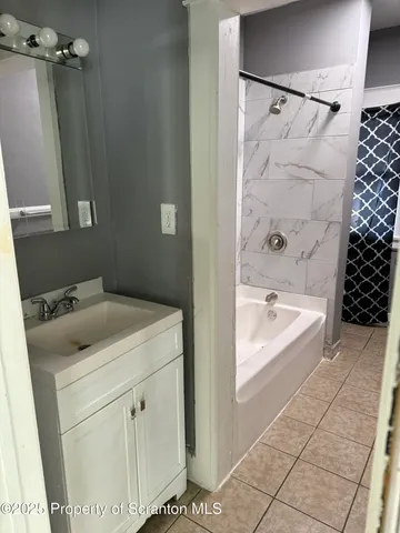 a bathroom with a sink and a bathtub with shower