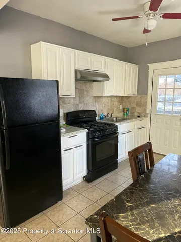 a kitchen with a refrigerator and a stove top oven