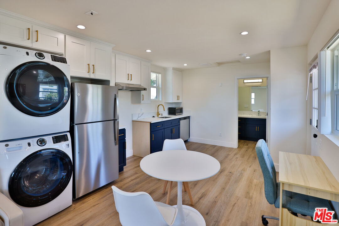 1237 West 25th Street, Unit 1241 1/2 Los Angeles, CA 90007 - Photo 11 of 16 a kitchen with stainless steel appliances lots of white furniture a refrigerator and a stove