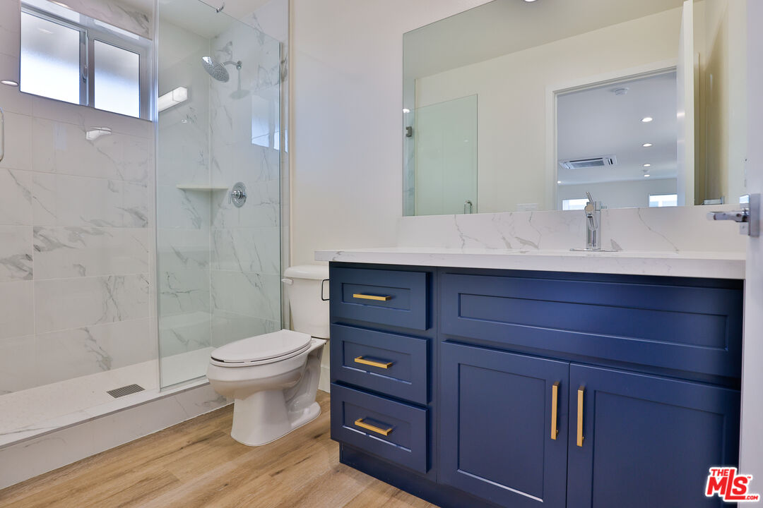 1237 West 25th Street, Unit 1241 1/2 Los Angeles, CA 90007 - Photo 14 of 16 a bathroom with a double vanity sink toilet and shower