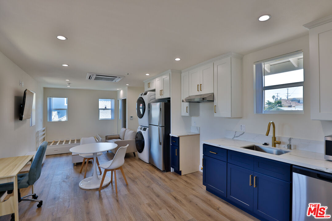 1237 West 25th Street, Unit 1241 1/2 Los Angeles, CA 90007 - Photo 4 of 16 a kitchen with a dining table chairs and refrigerator