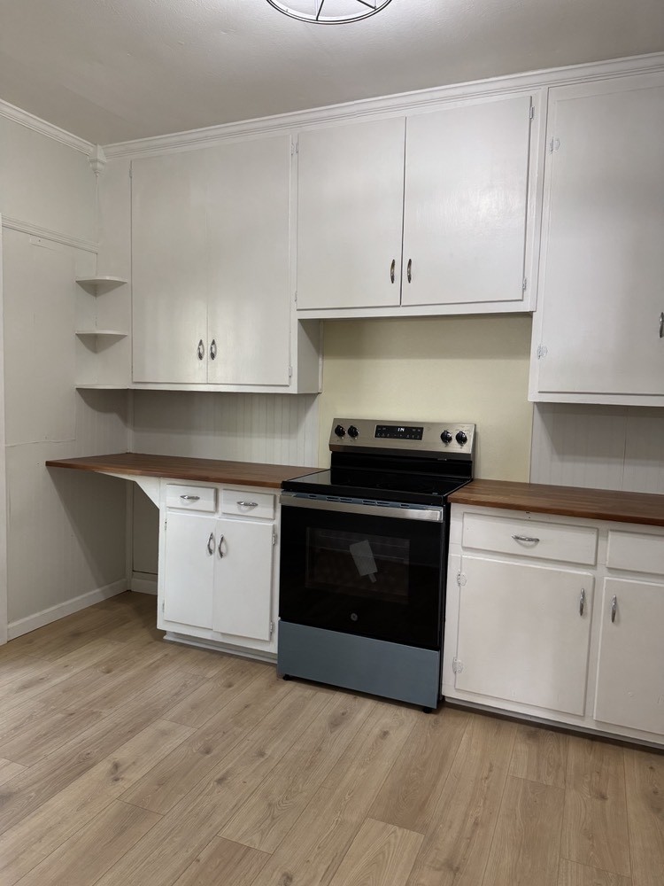 143 Morrison Street, Unit 1 Gallatin, TN 37066 - Photo 3 of 12 a kitchen with granite countertop white cabinets and stainless steel appliances