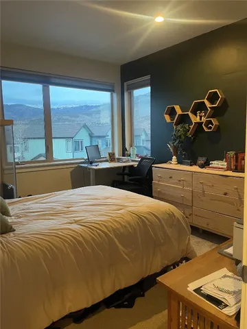 a bedroom with a bed and two window