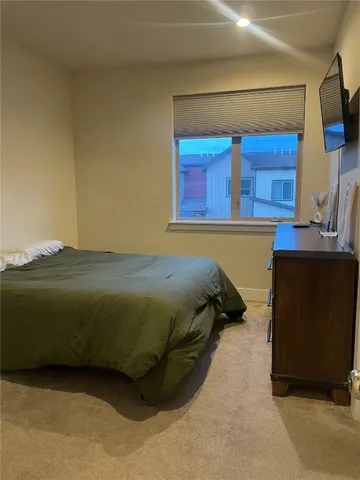 a bedroom with a bed and two windows
