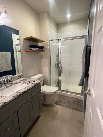 a bathroom with a granite countertop sink toilet and shower