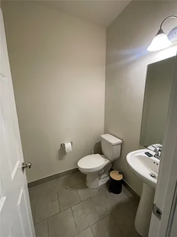 a bathroom with a toilet sink and a mirror