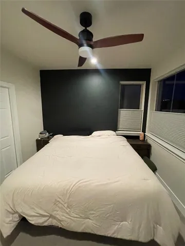a bedroom with a bed and a ceiling fan