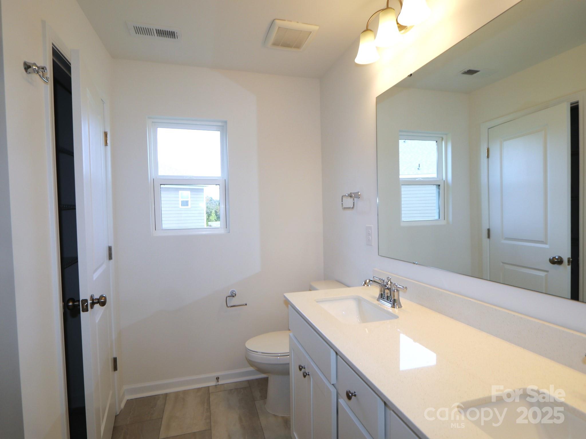 1008 Overbrook Place Wingate, NC 28174 - Photo 18 of 18 a bathroom with a granite countertop sink mirror vanity and toilet
