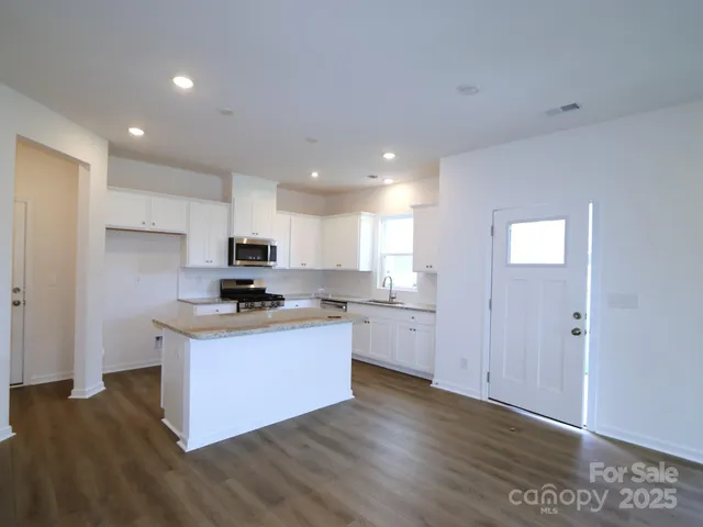a kitchen with granite countertop a sink and a stove top oven