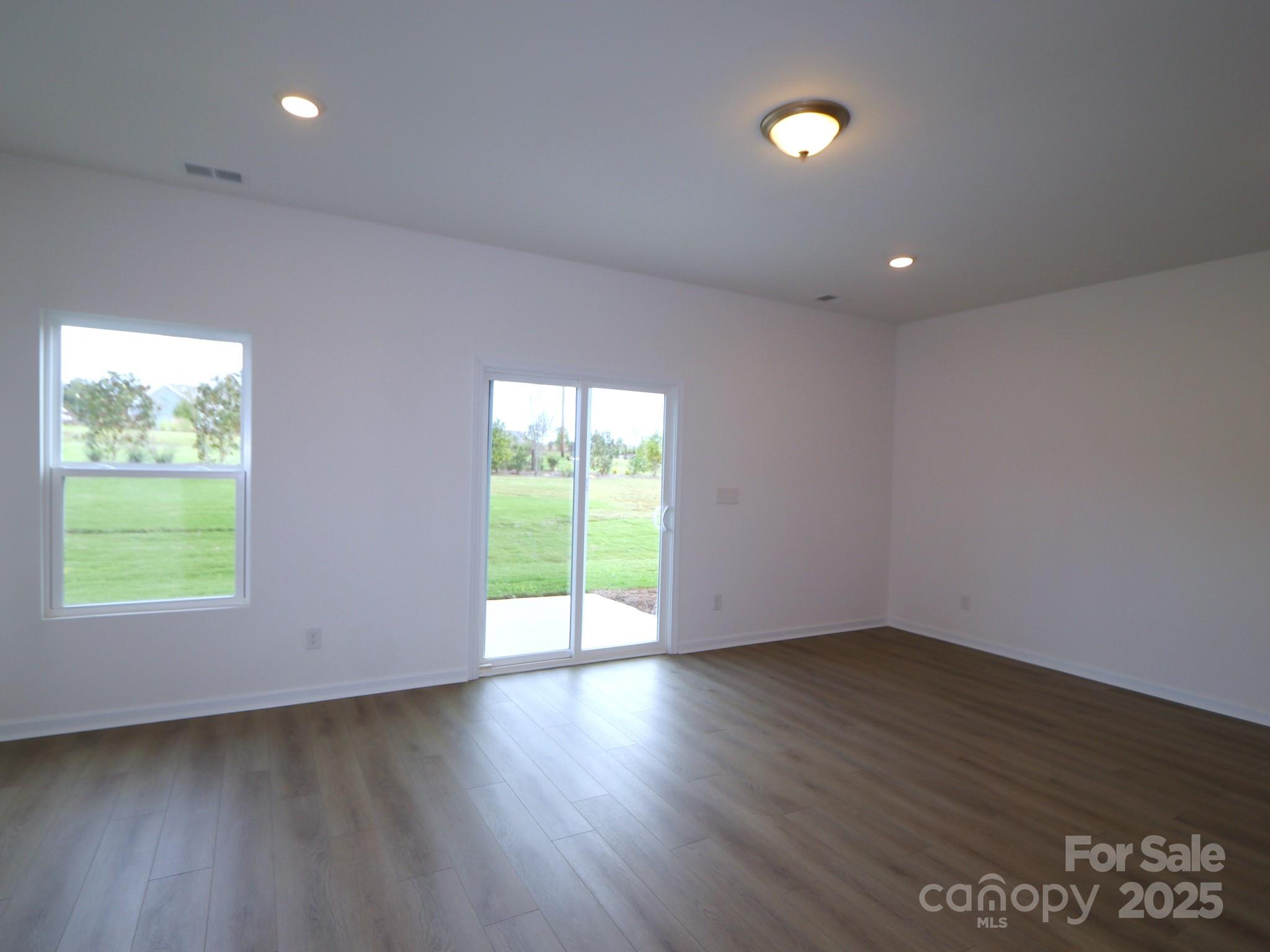 1008 Overbrook Place Wingate, NC 28174 - Photo 7 of 18 a view of an empty room with wooden floor and a window