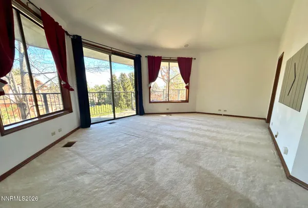 a view of an empty room with a fireplace and a large window