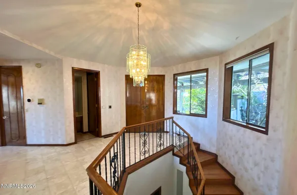 a view of a hallway with wooden floor and windows