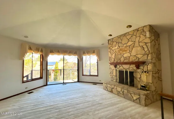 a view of an empty room with a fireplace and a window