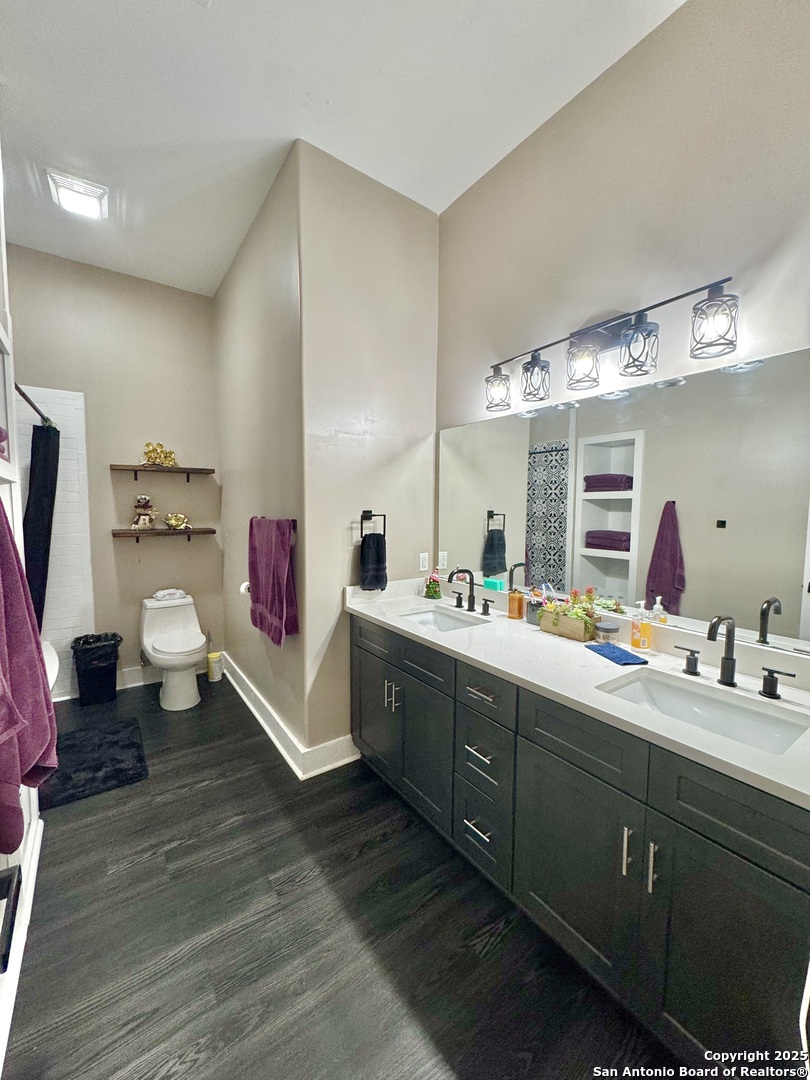 1106 North High Street Uvalde, TX 78801 - Photo 7 of 26 a kitchen with a sink cabinets and wooden floor