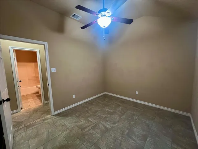 an empty room and chandelier fan