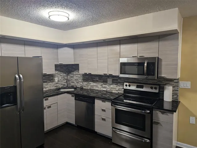 a kitchen with stainless steel appliances a stove microwave and refrigerator