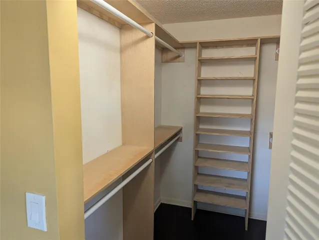 a view of walk in closet with empty racks