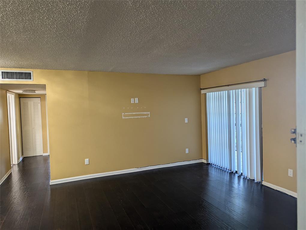 9612 West McNab Road, Unit 104 Tamarac, FL 33321 - Photo 4 of 8 an empty room with wooden floor