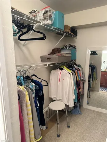a view of walk in closet with clothes and shoes