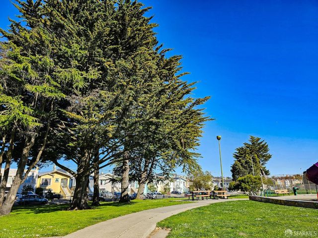 a view of swimming pool with lawn chairs and a big yard