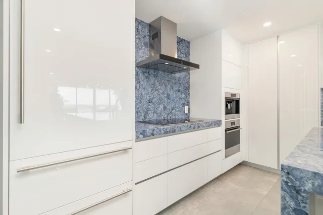 a kitchen with a refrigerator and white cabinets