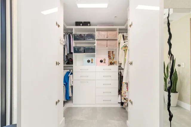 a view of walk in closet with clothes
