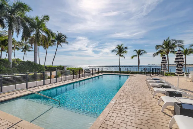 a view of swimming pool with outdoor seating and lake