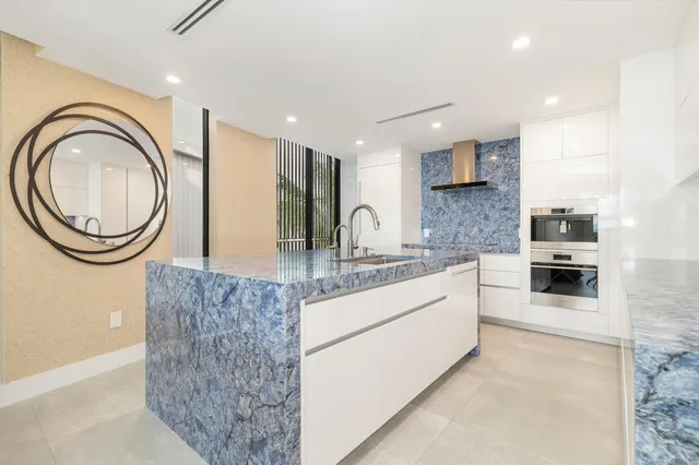 a large kitchen with stainless steel appliances granite countertop a granite counter tops and a view of living room