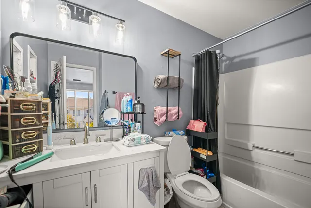 a bathroom with a sink vanity mirror and toilet