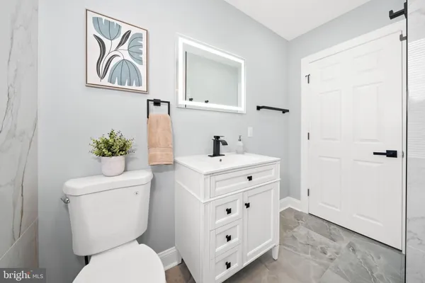 a bathroom with a sink mirror vanity and toilet